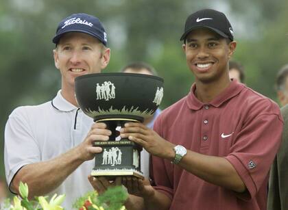 David Duval y Tiger Woods sostienen el trofeo del certamen, entregado por el presidente Fernando De la Rúa