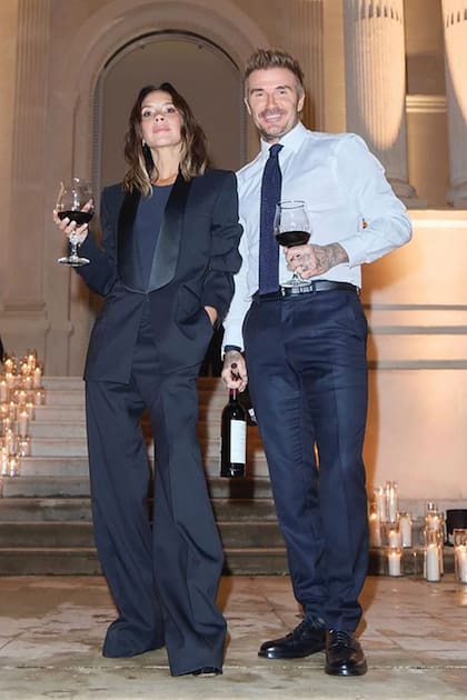 David y la diseñadora celebran el éxito del desfile con unas copas de vino tinto.