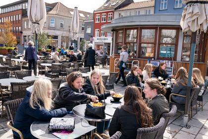 De comensales afuera de un restaurante para servicio al aire libre en Roskilde, Dinamarca, mientras reabran cafés y bares. 