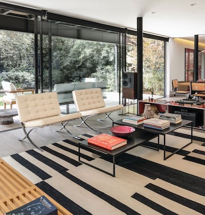 De espaldas al ventanal dos clásicas sillas Barcelona de Mies van der Rohe.