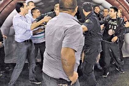 De espaldas, mientras discute con Palermo, el hombre deja ver el arma de fuego