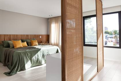 De este lado, el centro del panel está ocupado por un gran espejo que auxilia la zona de vestidor, potencia la amplitud y multiplica la luz. Respaldo con mesas de luz (Muchnik y Wainstein). Ropa de cama (todo de Lote Propio).