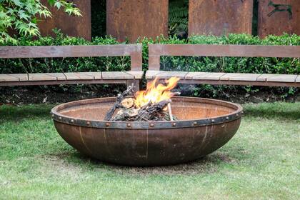 De hierro, tipo palangana, acompañado de bancos semicirculares, también de hierro y con asientos de madera.