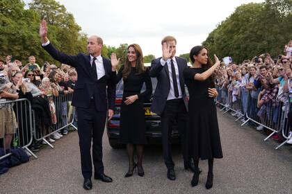 De izquierda a derecha, el príncipe británico Guillermo, príncipe de Gales, Kate, princesa de Gales, el príncipe Harry y Meghan, duquesa de Sussex saludan al público en el castillo de Windsor, tras la muerte de la reina Isabel II el jueves, en Windsor, Inglaterra, el sábado 10 de septiembre de 2022. 