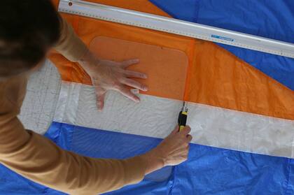 De los aproximadamente 40 metros cuadrados de tela de un parapente, Desimone puede extraer alrededor de 100 mochilas