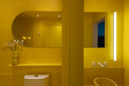 De los revestimientos a las mesadas de terrazo (Pimux Terrazo), todo en el baño es monocromo. El juego de un espejo que parece continuo apunta a integrar el ante baño con el baño en sí.