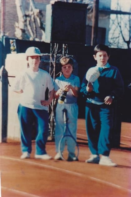 De niño, en el medio, ya con la raqueta