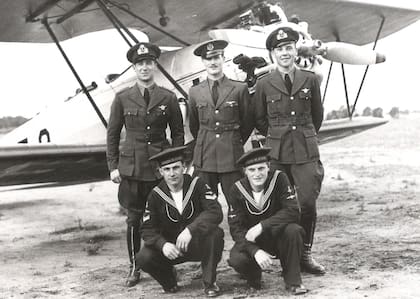 De pie y al centro el instructor Suboficial Aeronáutico piloto de hidroavión Luis Pefaure de recordada trayectoria en la Aviación Naval Argentina junto a dos alumnos suyos recibidos de aviadores navales en la pista de Campo Sarmiento, Base Naval Puerto Belgrano. (Cortesía Luis Pefaure).