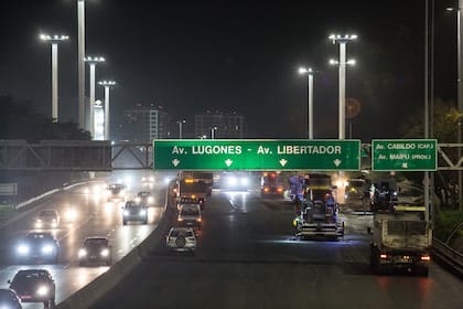 De una lado, las máquinas y las cuadrillas de operarios que trabajan en la repavimentación de la traza; del otro, la circulación de vehículos particulares