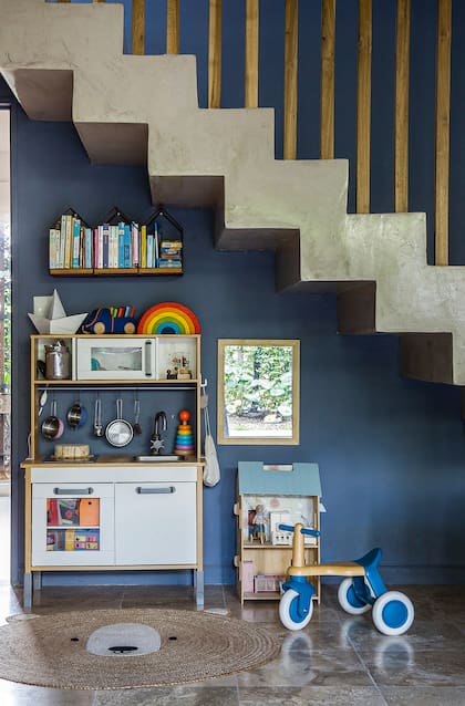 Debajo de la escalera, hoy hay un espacio de juegos. Cocinita Ikea, casita Yoko y un triciclo que trajo de Uruguay