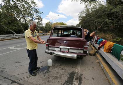 Debido a la falta de agua, un hombre lava el auto con agua recolectada de el Parque Nacional El Ávila