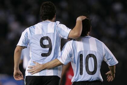 Debut y gol: Messi lo saluda después de su grito ante Perú en octubre de 2009, en el Monumental. Esa noche se puso por primera vez la camiseta de la selección, con Maradona como DT. Empezaba un camino que incluyó tres mundiales.