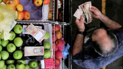 Decenas de billetes para hacer una compra básica en Venezuela