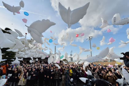 Decenas de globos en forma de palomas son arrojados al aire para recordar los 20.000 muertos por Fukushima