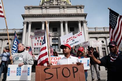 Decenas de personas que piden detener el conteo de votos en Pensilvania debido a un presunto fraude contra el presidente Donald Trump se reúnen en las escaleras de la capital del estado el 5 de noviembre de 2020 en Harrisburg, Pensilvania