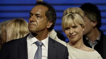 Decepcionado, Scioli luego de perder las elecciones. Atrás, su entonces esposa, Karina Rabolini