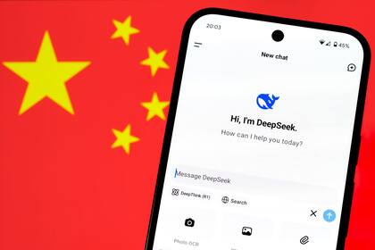 DeepSeek AI app chat seen on the smartphone and blurred Chinese flag on the background. Concept for a new chinese AI rival to ChatGPT. Stafford, United Kingdom, January 26, 2025