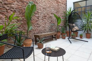 Dejaron la pared del patio con ladrillos a la vista para mantener la impronta de un PH centenario. Los baldosones son atérmicos, no resbalan y son de fácil colocación y mantenimiento.