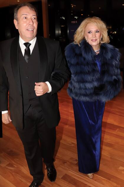 Del brazo de Alejandro Veroutis, uno de sus colaboradores, llega al Centro Cultural Kirchner para la Comida Anual Solidaria de la Fundación Fernández vestida con un diseño de chiffon de seda natural con plumas en azul Francia, de la firma Iara, y saco de piel ecológica de Breeders.