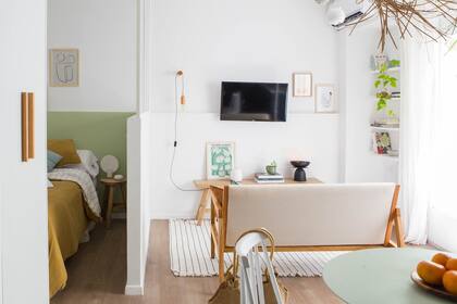 Del lado del dormitorio, la pintura verde a la altura del murete funciona como respaldo y crea una nueva diferencia con el living.