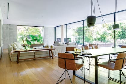 Mesa ‘Margen’, sillas ‘Horqueta’ con respaldo tapizado (todo de Federico Churba) y lámpara orientable ‘Aim’, de los hermanos Ronan y Erwan Bouroullec para la firma italiana Flos. A la izquierda, arriba, spots circulares se embuten en el cielo raso y liberan la vista para ampliar (más) el espacio.