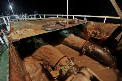 Grandes chorros de arena y agua van cargando lentamente el barco, el agua será descartada y quedará solamente la arena que será llevada al puerto
