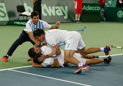 Delbonis, tapado por varios compañeros del equipo argentino de la Copa Davis en Zagreb, tras ganar el histórico quinto punto ante Croacia