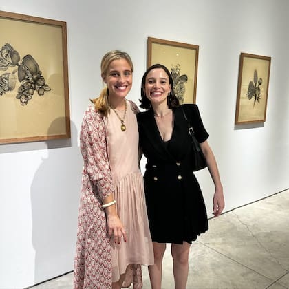 Delfina Braun posa sonriente junto a Manuela Hansen, curadora de la muestra.