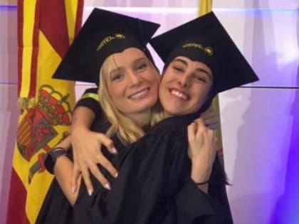 Delfina Lanusse y Chantal Leclercq se abrazan y sonríen durante un acto de graduación, ambas con toga y birrete en la Universidad Austral