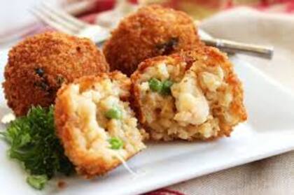 Deliciosos conos de arroz relleno fritos originarios de Italia