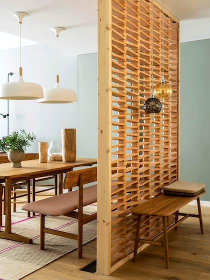 Dentro de un marco de madera, las tejuelas de la colección ‘Tierras’, creadas por la española Patricia Urquiola para Mutina, forman una pared semitransparente que divide sin perder continuidad.