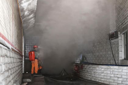 Un trabajador de rescate mide la densidad del monóxido de carbono en el smog en la entrada de la mina de carbón en el distrito de Chongqing