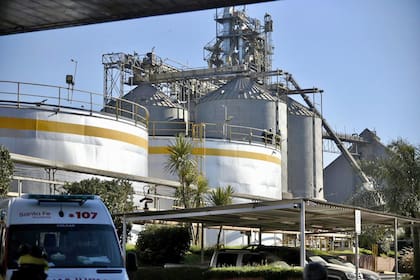 Personal de bomberos de la zona y prácticos de Prefectura, con el apoyo de médicos de dos servicios de emergencia, tratan de asistir con oxígeno a la persona atrapada, mientras pesadas máquinas trabajan para retirar el cereal que se acumuló en el lugar