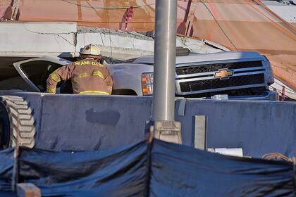 Bomberos y rescatistas remueven escombros para retirar los cuerpos de las personas que murieron tras el derrumbe
