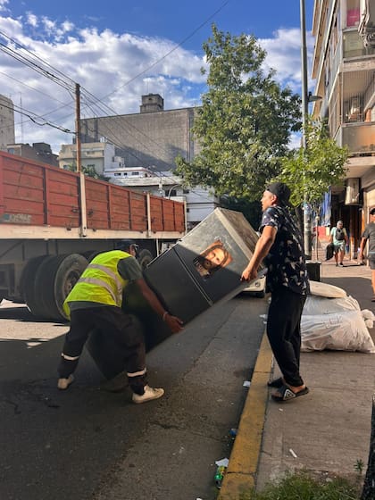 Personal del gobierno porteño retirando pertenencias de los ocupantes desalojados en camiones de mudanza durante el operativo