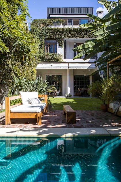 Desde el jardín se distingue la nueva construcción, una estructura metálica revestida en chapa que se posa sobre la cubierta, con vigas que descargan directamente en los muros perimetrales.