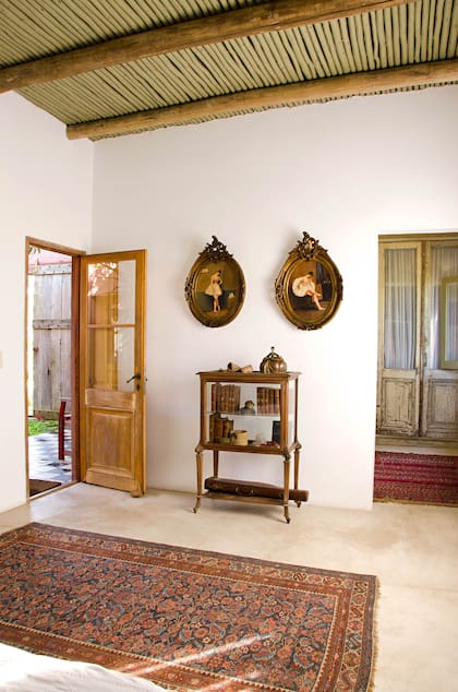 Desde el patio se entra directamente a la suite principal. La mayoría de sus muebles se compraron en un remate en Montevideo. Es el caso del gabinete art nouveau y los dos cuadros de la Belle Époque. La alfombra persa es una pieza auténtica del siglo XIX