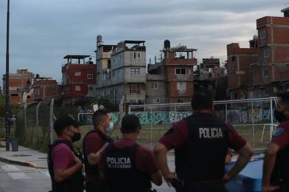 Desde la avenida Triunvirato, un grupo de efectivos de la comisaría 15A de la Policía de la Ciudad vigilan El Playón, el asentamiento de la calle Fraga situado detrás de la estación Federico Lacroze del ferrocarril Urquiza