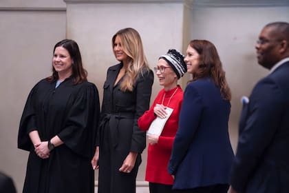Desde la izquierda, la jueza Elizabeth Gunn, y la ex primera dama Melania Trump dan la bienvenida a los ciudadanos estadounidenses en una ceremonia de naturalización, en Washington, el viernes 15 de diciembre de 2023. (AP Photo/J. Scott Applewhite)