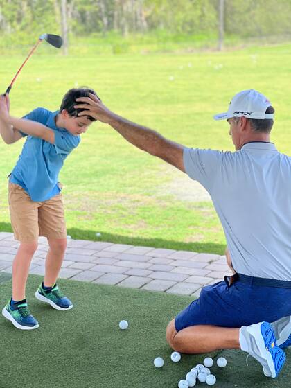 Desde muy chicos, los alumnos aprenden los swings y cómo comportarse como golfistas; en la imagen, con el coach Hernán Rey