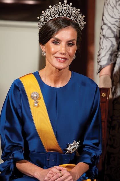 Desde su asiento en el Palacio Real, Letizia impactó con el diseño de la firma española The 2nd Skin Co, una tiara de platino, perlas y diamantes en forma de lágrimas de Cartier, pendientes y un broche de diamantes con una perla. 