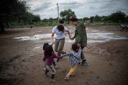 Dos voluntarias de la ONG Pata Pila juegan con niños de la comunidad El Cañaveral 1
