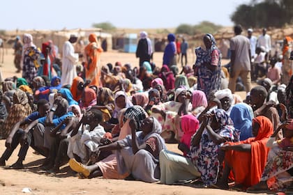 Desplazados esperan sentados para recibir ayuda humanitaria