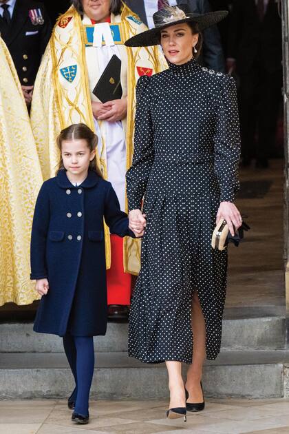 Después de la gira al Caribe, la duquesa de Cambridge, que llegó de la mano de su hija Charlotte, lució un vestido fluido con lunares y hombros marcados de la firma británica Alessandra Rich que complementó con stilettos Gianvitto Rossi, clutch de Russell & Bromley y sombrero de ala ancha en rafia con cinta y pluma.