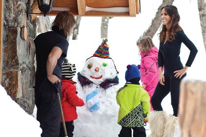 Después de mucho trabajo, Facu, María y sus hijos, felices con el muñeco de nieve que hicieron entre todos.