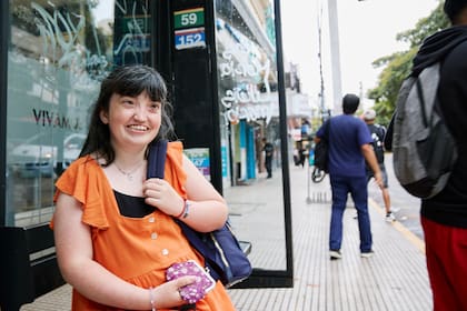 Después de una breve caminata desde su casa, Cande espera el 152 en la parada.