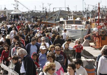 Después de una hora de espera para almorzar, los turistas pasearon por la banquina de pescadores