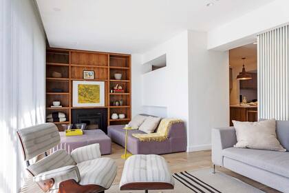 En el living, biblioteca de incienso (diseño Zunino Grillo) con cuadro del artista Pablo Scheibengraf. Al lado, sofá ‘Shape’ en lila grisáceo con puf estilo otomano (Manifesto). A la derecha, la cocina.