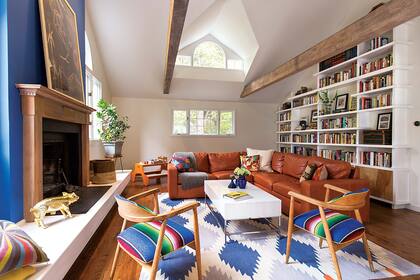 Esta familia joven y con ganas de pasarla bien en su casa eligió muebles cómodos y prácticos, como este sillón esquinero de cuero color teja que aguanta todo (Room Board).