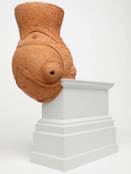 Detalle de Hornero, escultura de adobe colocada sobre un pedestal